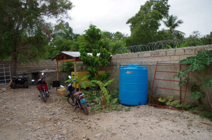 Rainwater is collected next to the diesel backup generator within the guest house walled compound.  The parking lot held all manner of bikes, trucks, and vans as the week went on.